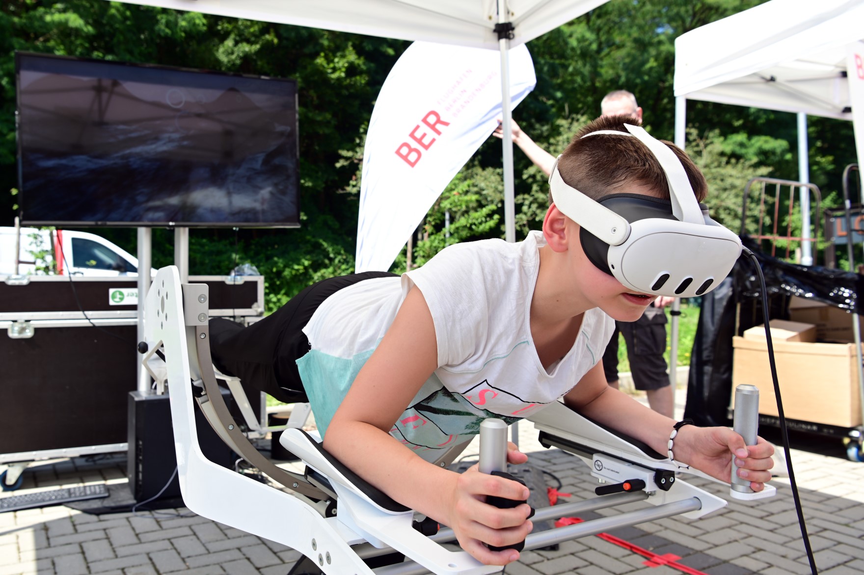 Kind mit Virtual Reality Brille auf dem Kopf auf einem Flugsimulator.