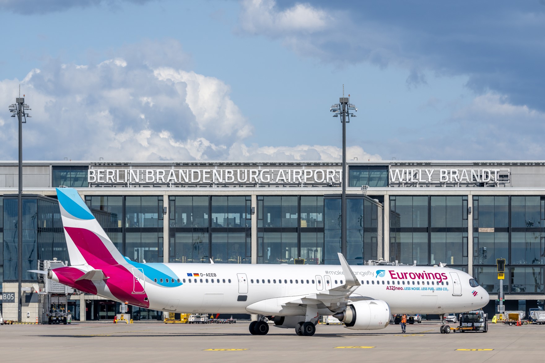 Ein Flugzeug der Fluggesellschaft Eurowings steht am Terminal des Flughafens BER, im Hintergrund ist der Schriftzug des BER zu sehen