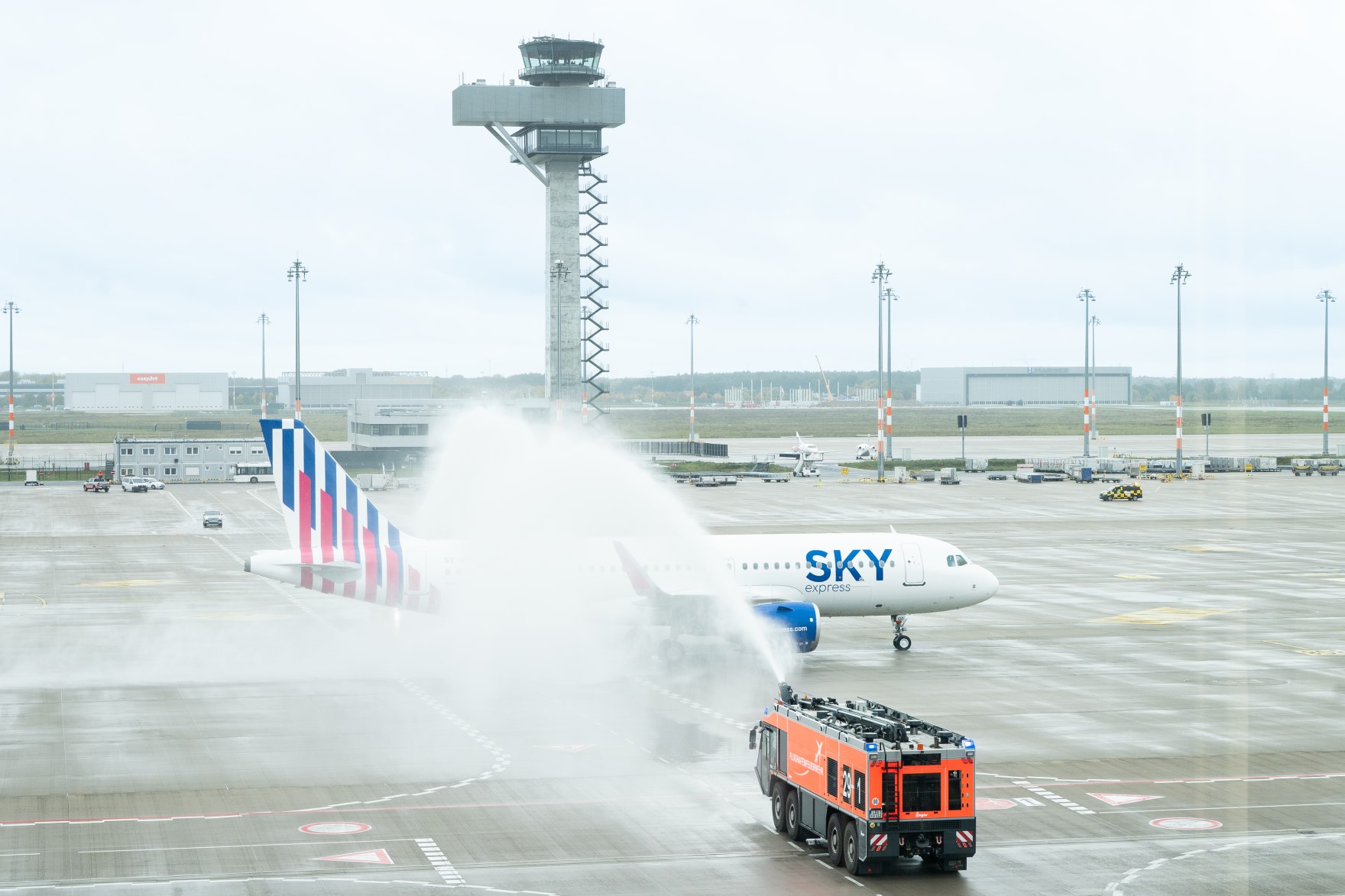 Ein Flugzeug wird durch die Flughafenfeuerwehr mit einer Wasserfontäne begrüßt.