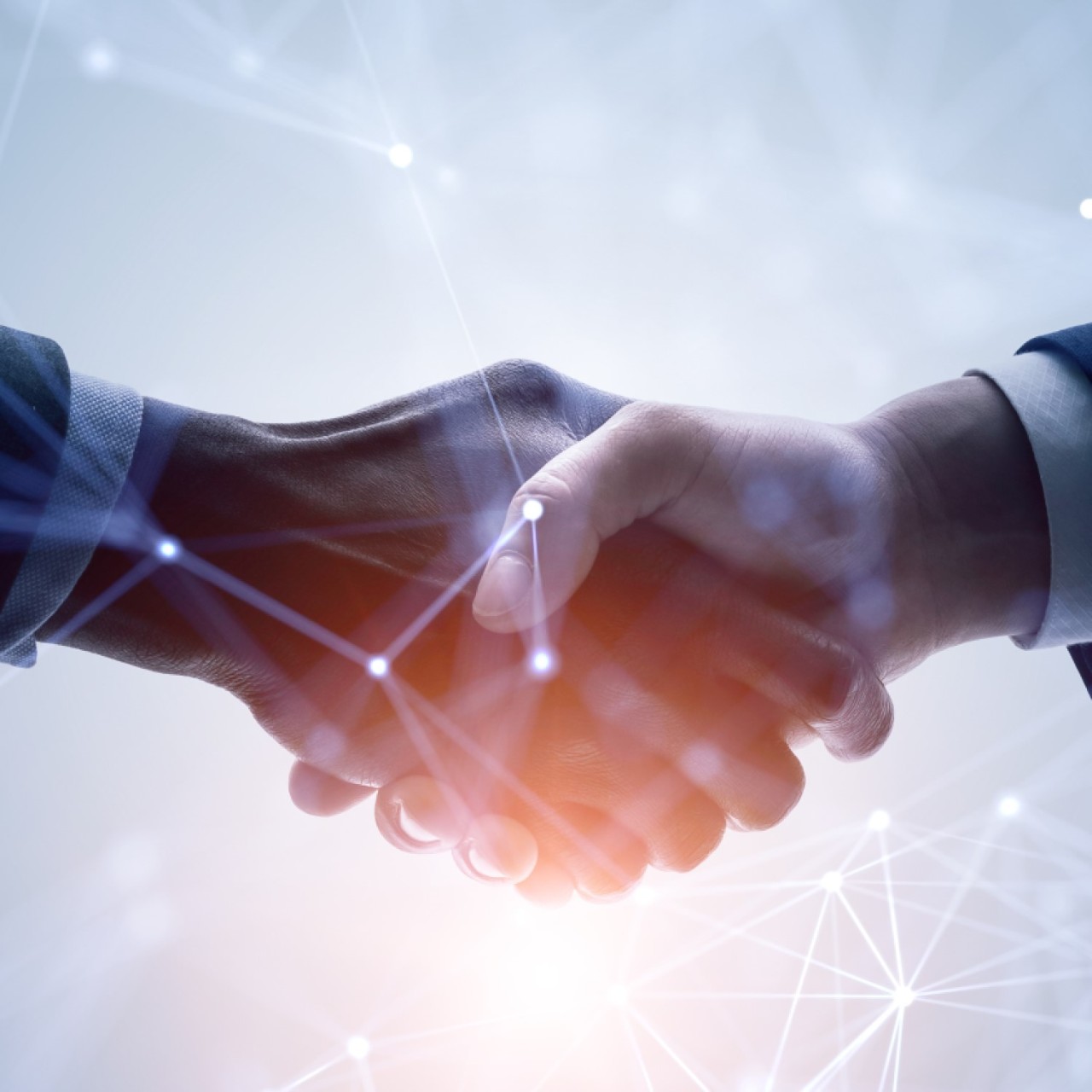 2 Hände, die sich schütteln. Darüber ein simuliertes Netzwerk. 