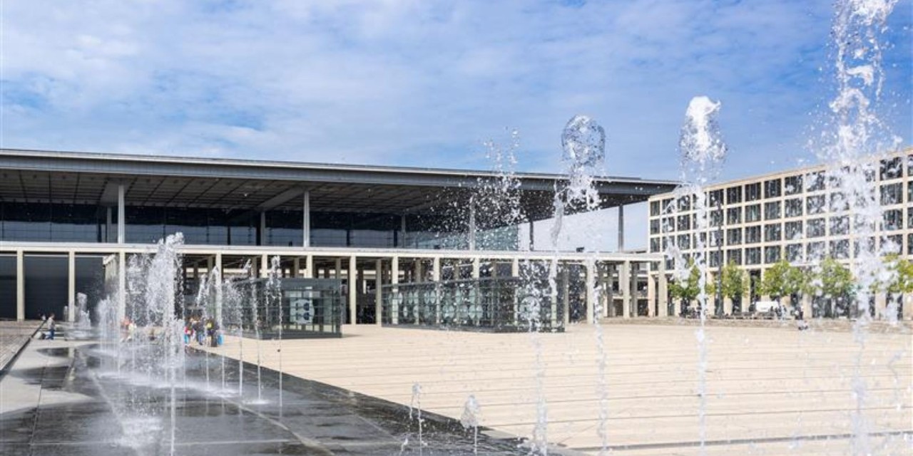 Springbrunnen im Vordergrund. Dahinter der Willy Brandt Platz und das Terminal 1.
