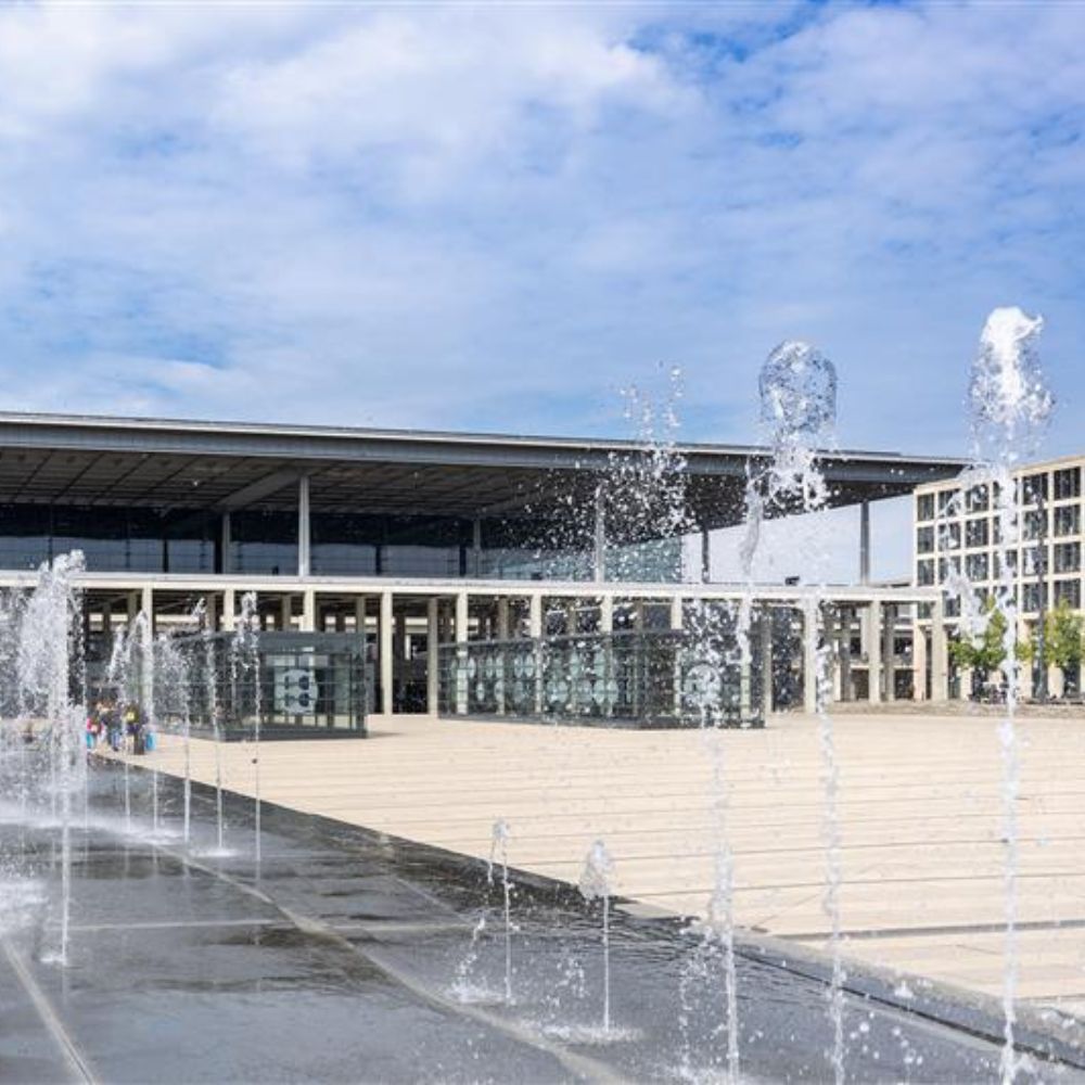 Springbrunnen im Vordergrund. Dahinter der Willy Brandt Platz und das Terminal 1.