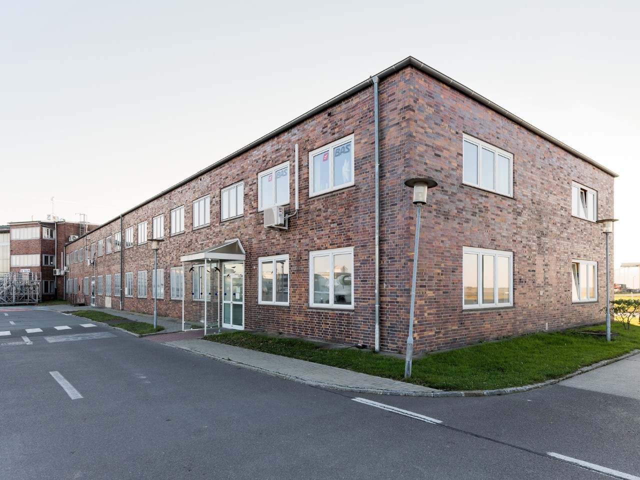 Ein altes Gebäude aus Backstein. Davor eine Straße.