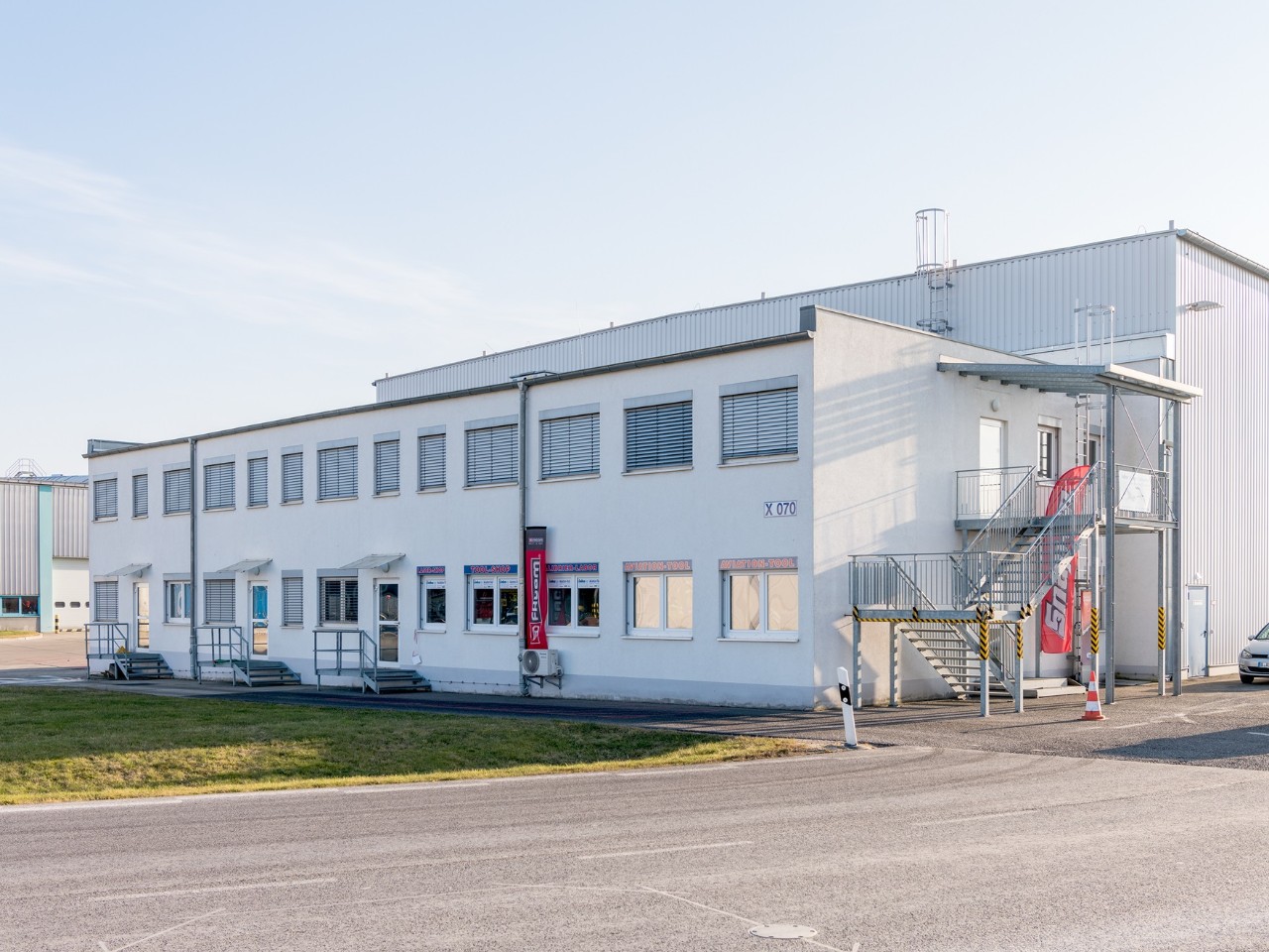 Ein weißes Gebäude. Davor eine Straße.