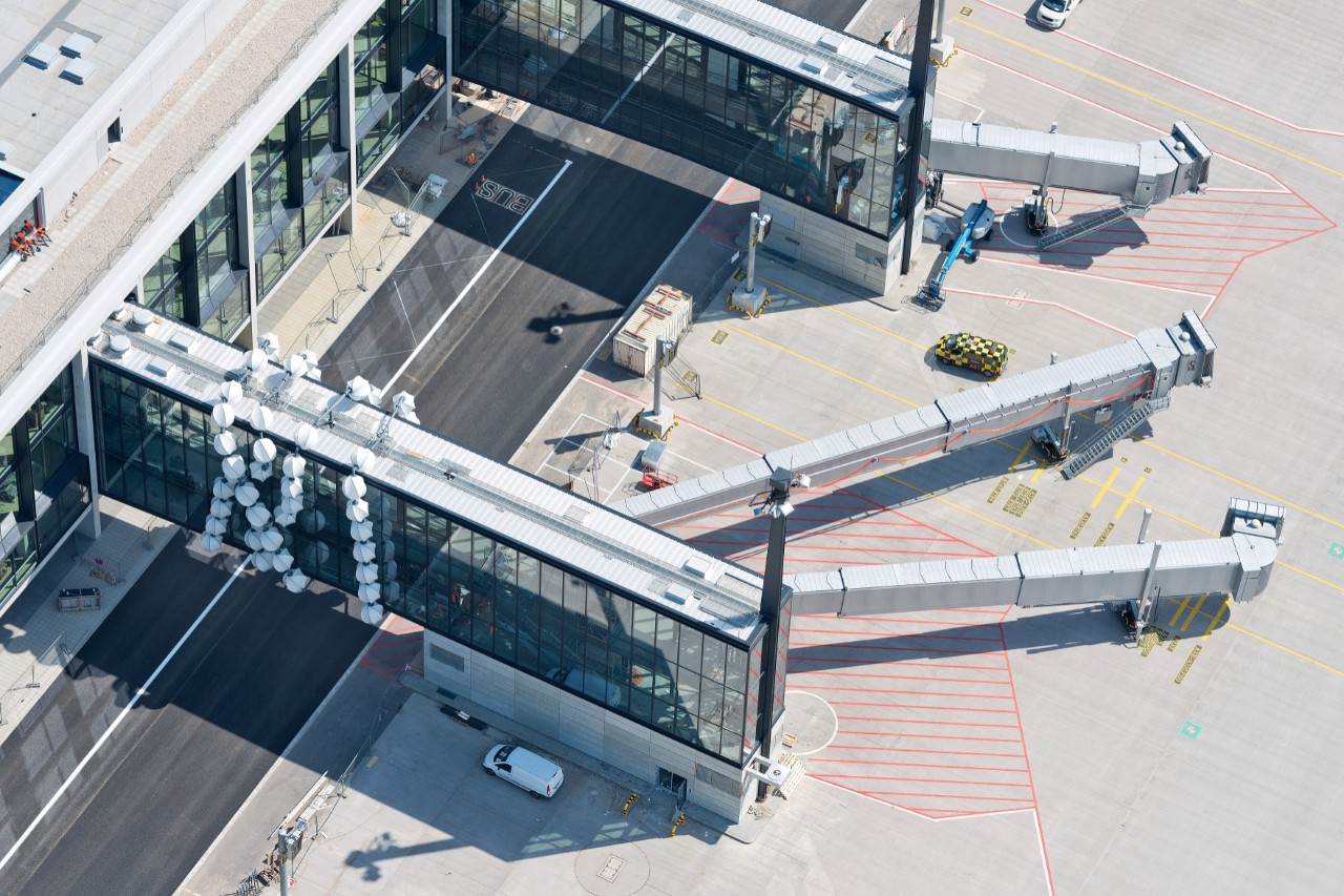 Luftaufnahme eines Teils des Vorfelds des BER mit Fluggastbrücken und Abfertigungsflächen für Flugzeuge