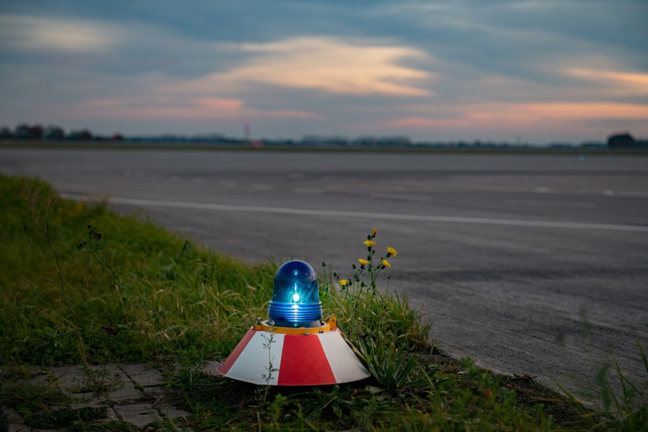 Landebahn-Randbefeuerung vorne. Im Hintergrund Vorabend-Himmel.