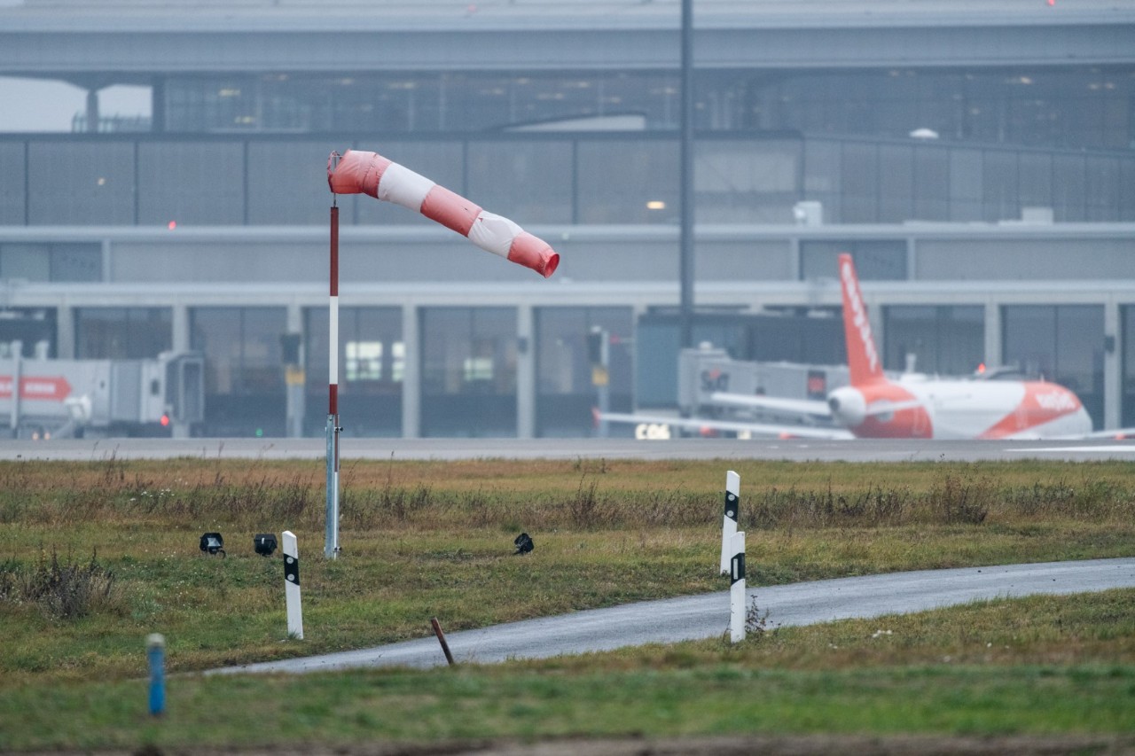 Ein Windrichtungsanzeiger (auch Windsack genannt) wird vom kräftigen Wind über dem Flughafengelände in eine fast waagerechte Position gebracht.