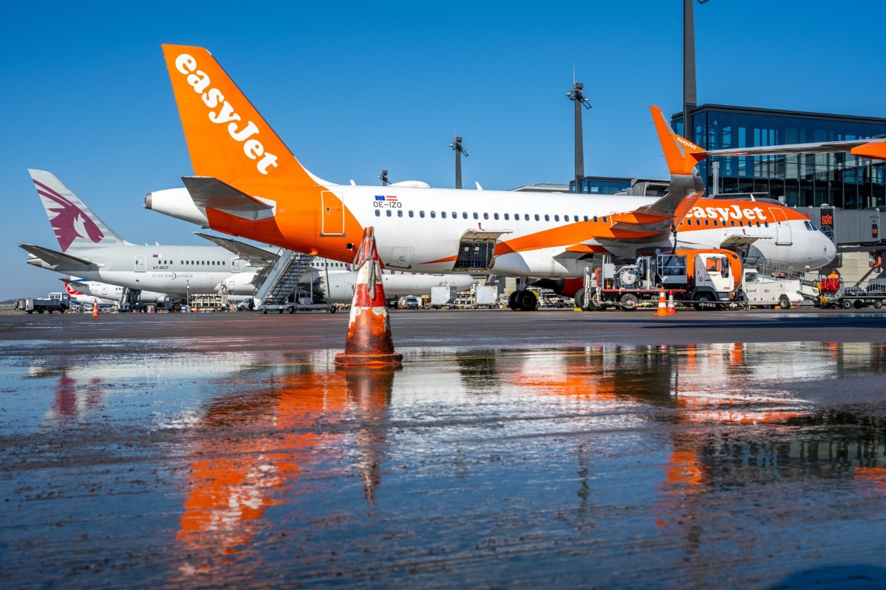 Zwei Flugzeuge auf dem Vorfeld, das von Regen nass glänzt