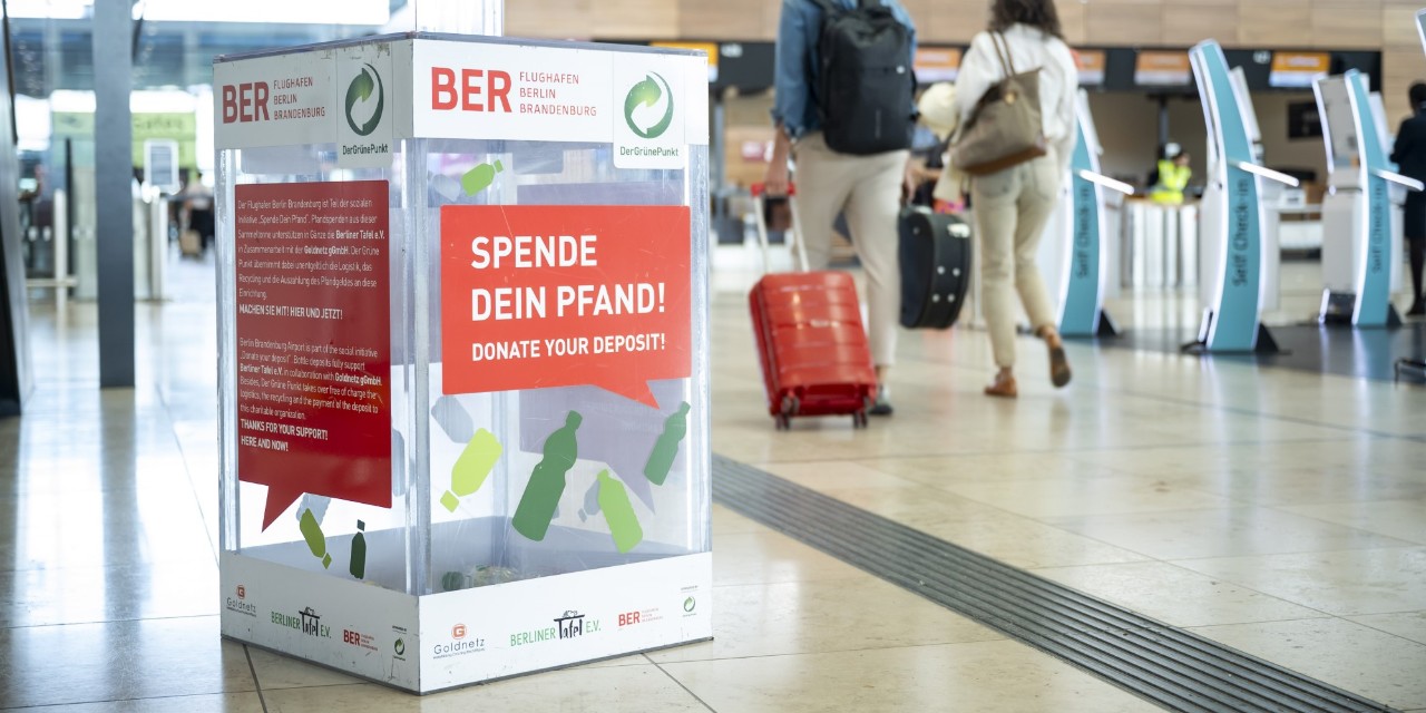 Eine Plastikbox zur Sammlung von Pfandspenden steht in der Check-in-Halle des Terminal 1 des BER.