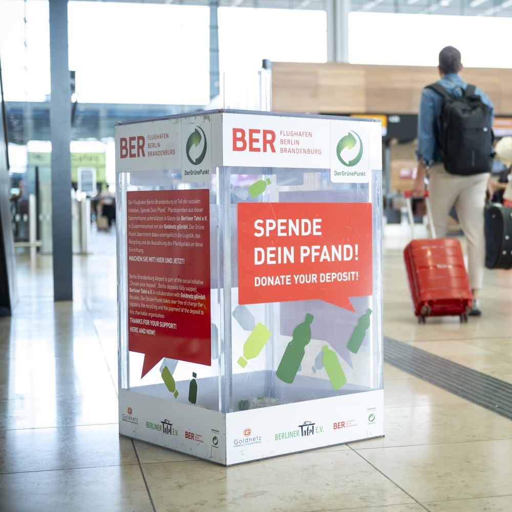 Eine Plastikbox zur Sammlung von Pfandspenden steht in der Check-in-Halle des Terminal 1 des BER.