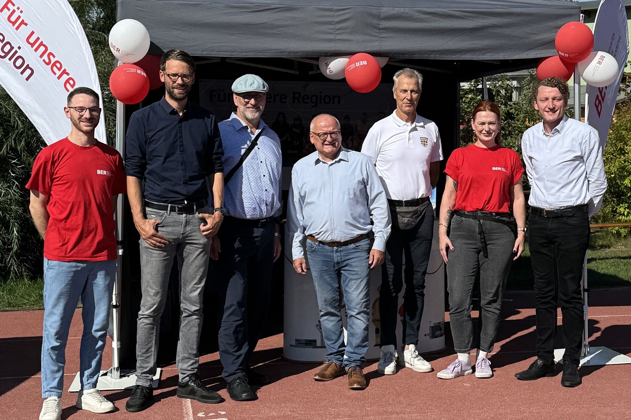 Eine Gruppe Menschen vor einem Pavillion mit Luftballons