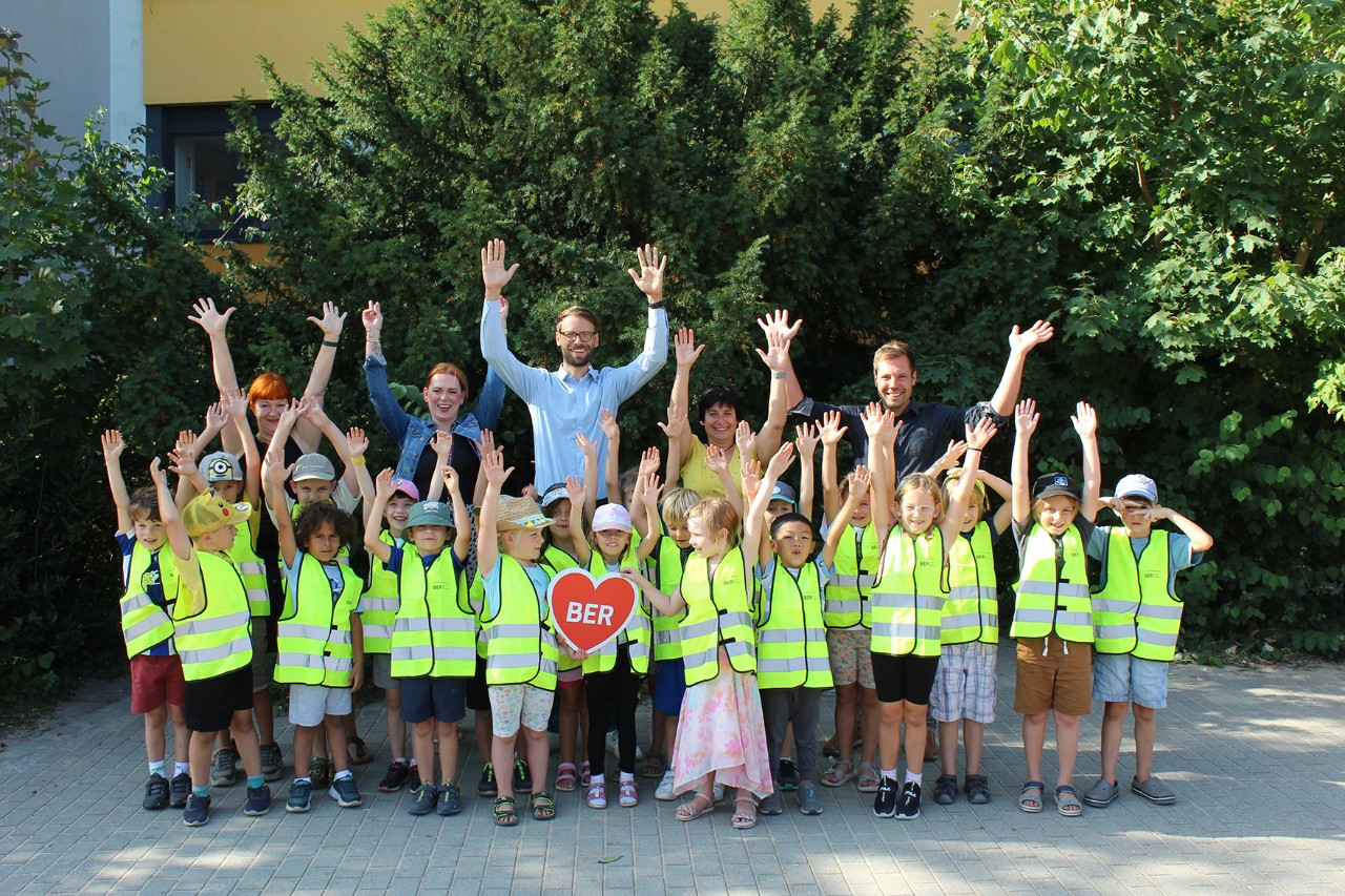 Eine Gruppe Kinder in Warnwesten und Erwachsene