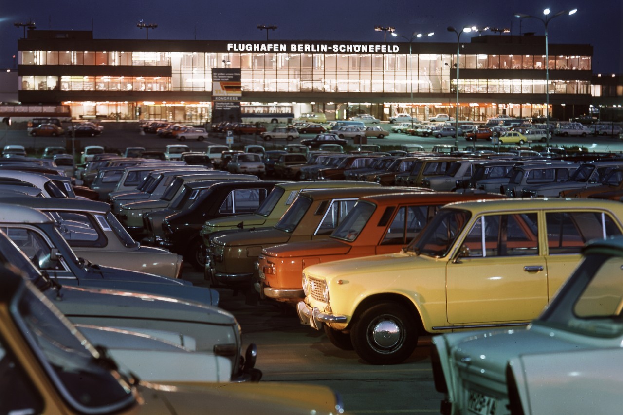 Historisches Bild mit Parkplatz voller Autos bei Nacht vor dem ehemaligen Flughafen Schönefeld