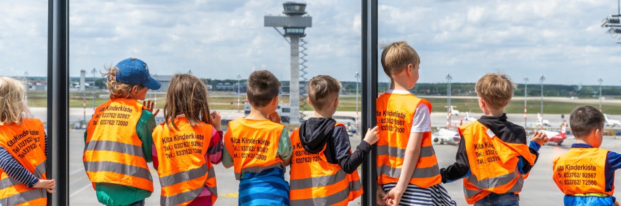 Kinder schauen dem Flugbetrieb von der Besucherterrasse aus zu