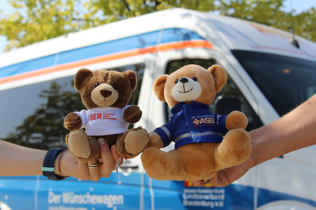 Zwei Teddybären werden von zwei verschiedenen Händen gehalten.