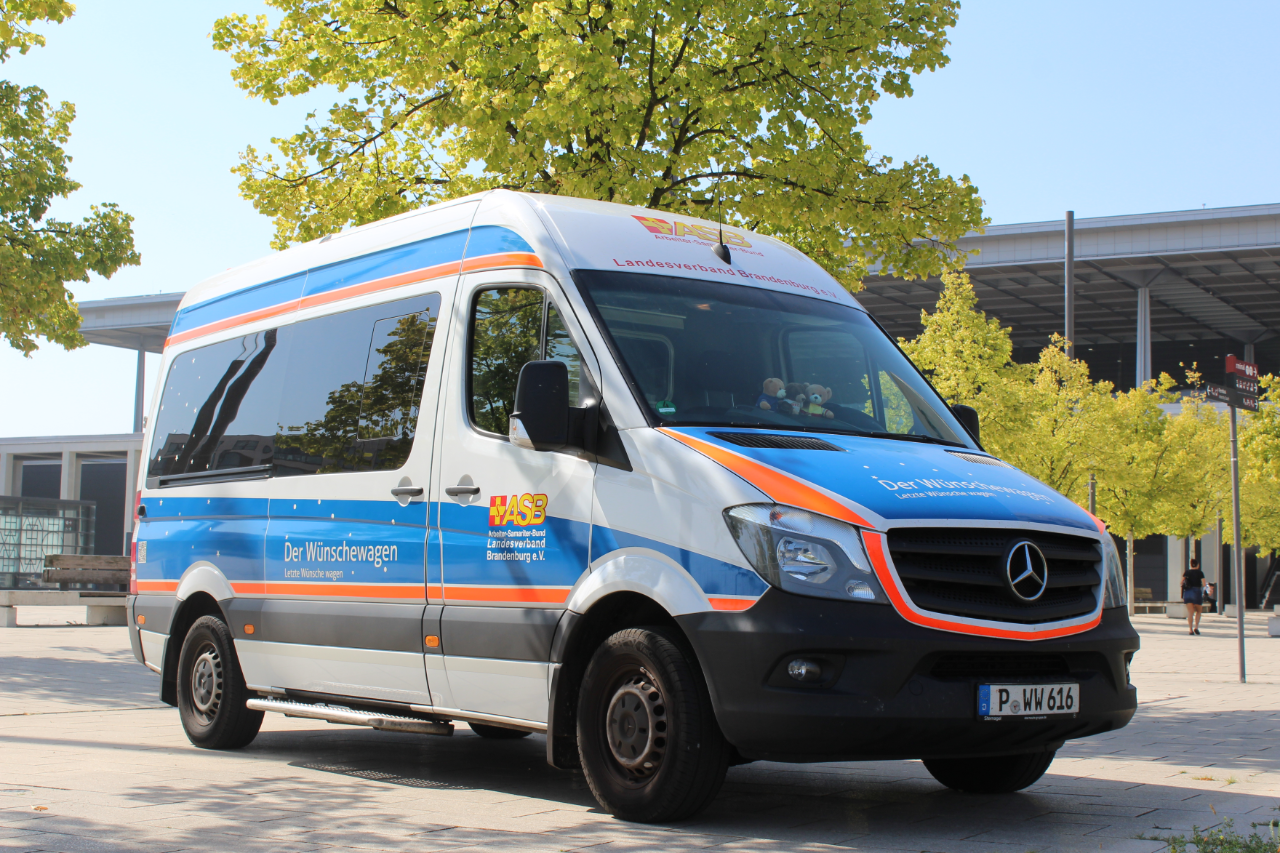 Ein blau-weißer Van auf einem großen Platz.