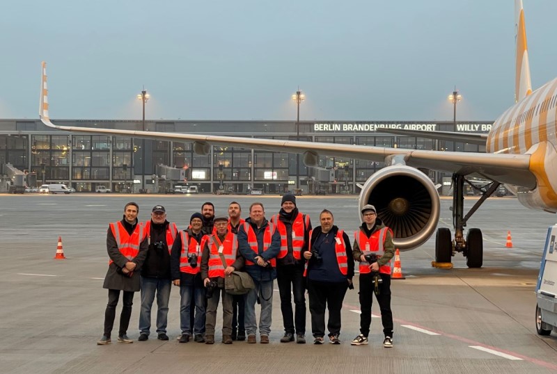 Menschen in roten Warnwesten an einem Flughafen