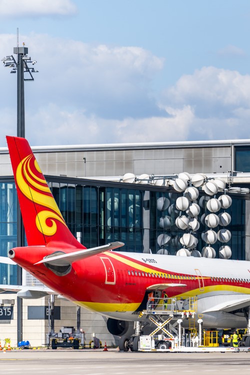 Das Heck eines Flugzeugs der Fluggesellschaft Hainan vor dem Terminal des BER