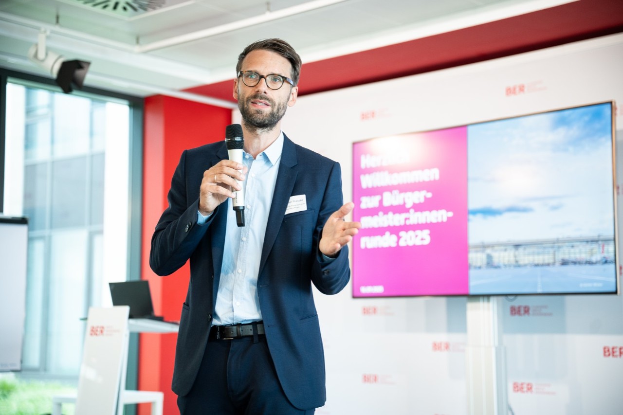 Ein Mann im Anzug mit einem Mikrofon in der Hand