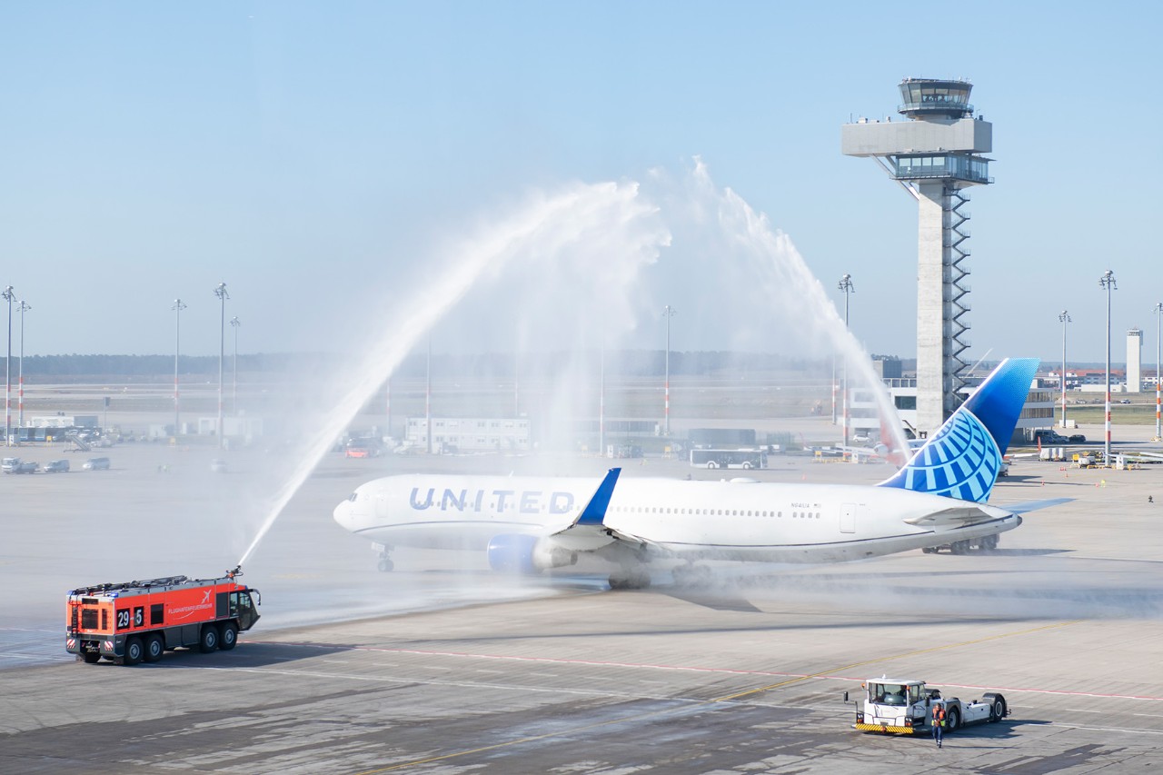 United Airlines Maschine auf dem Vorfeld mit Flughafenfeuerwehr und Wasserfontäne