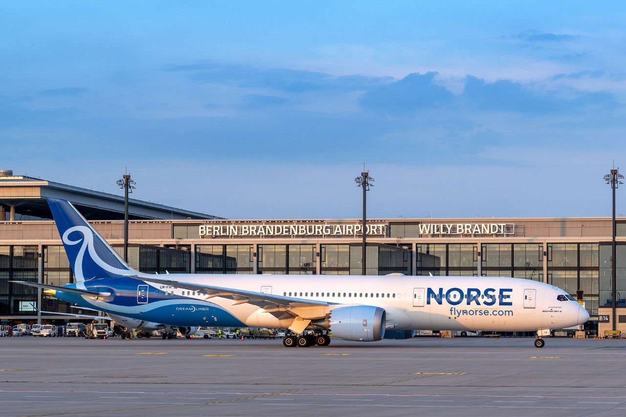 Norse Atlantic Airways Maschine auf Vorfeld im Sonnenuntergang; Terminal im Hintergrund