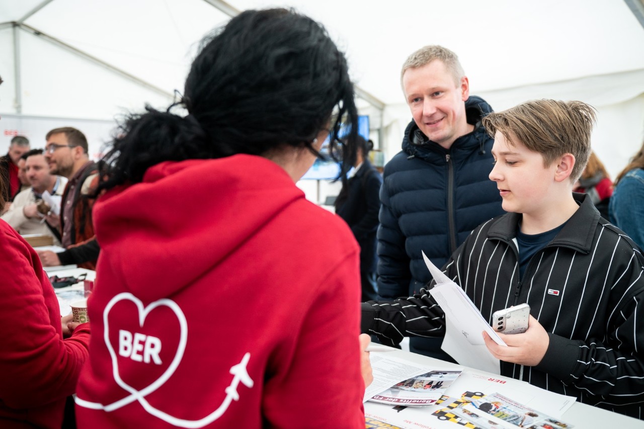 Besuchende und Mitarbeitende am Messestand auf der Jobmesse