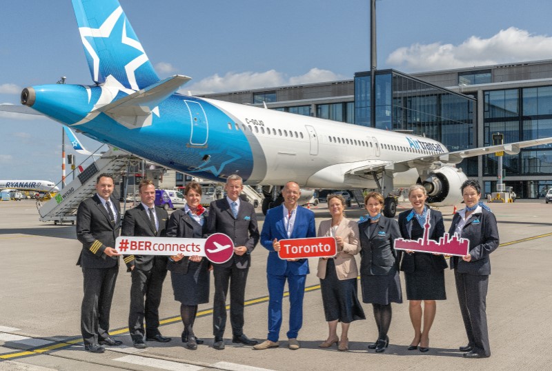 Viele Personen vor einem Flugzeug, das am Terminal 1 steht.