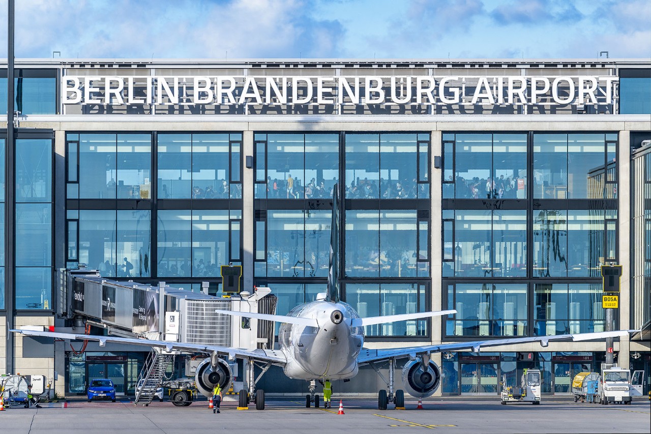 Ein Flugzeug steht auf dem Rollfeld. Im Hintergrund ist das Terminal zu erkennen.