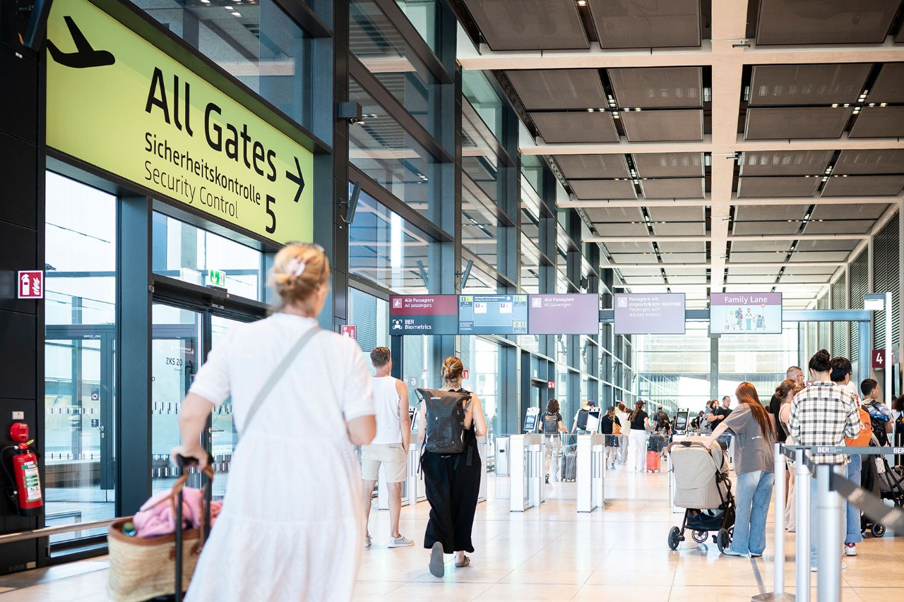 Reisende laufen mit ihrem Gepäck zu ihren Gates.