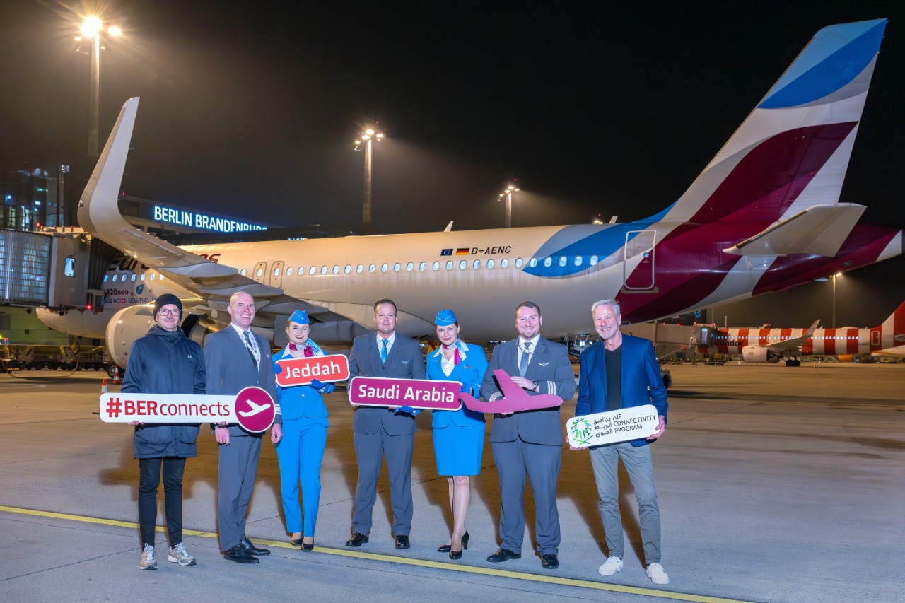 Personen stehen auf dem Vorfeld vor einem Flugzeug der Fluggesellschaft Eurowings 