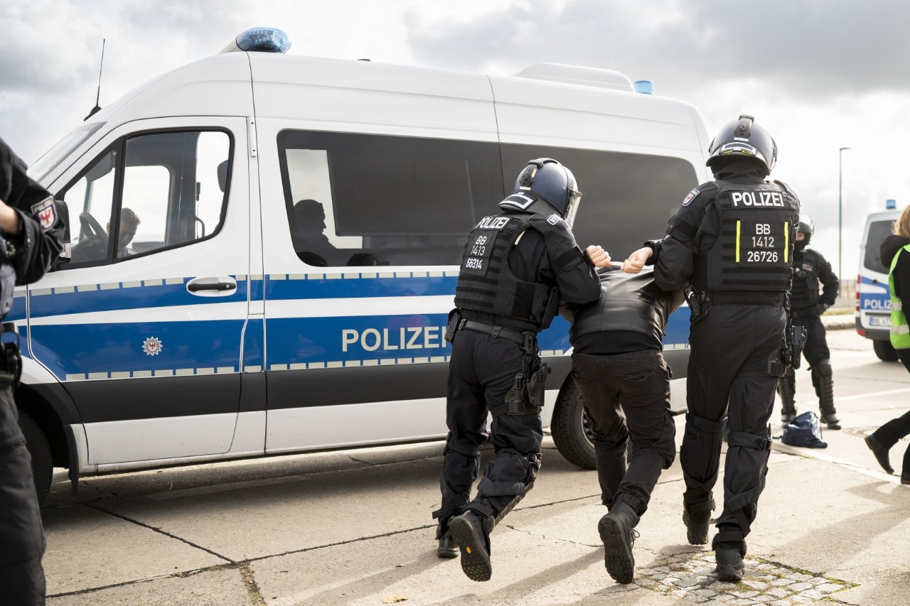 Polizisten führen eine Person ab
