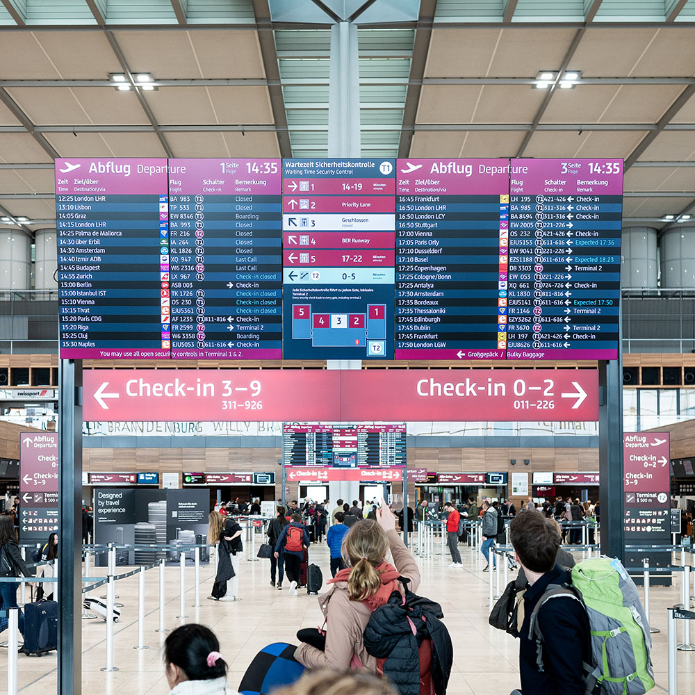 Reisende und BER Mitarbeitender im Terminal 1