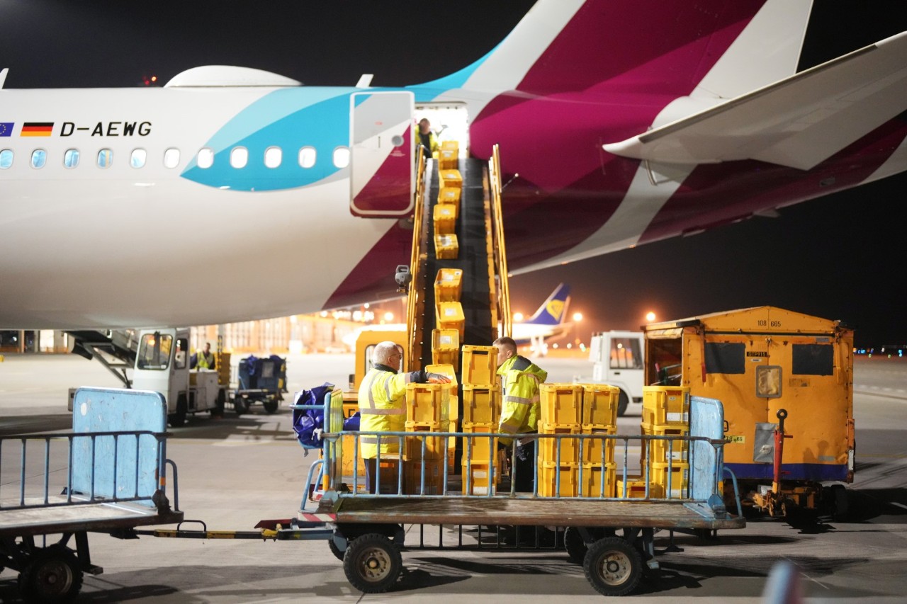 Boxes are loaded onto an aircraft via a conveyor belt