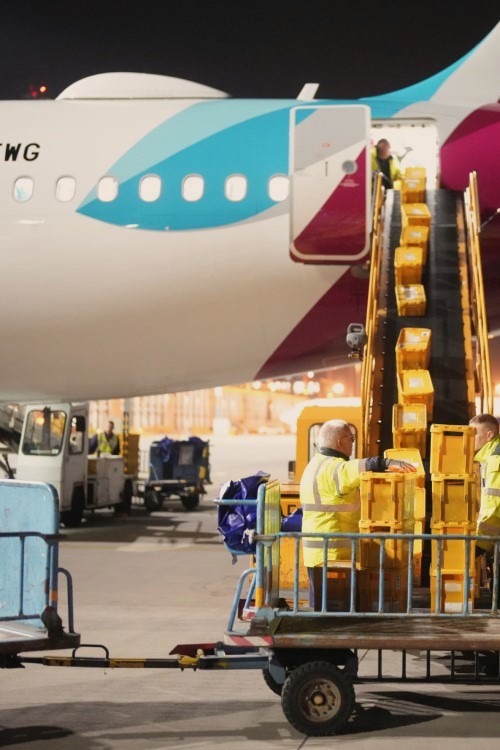 Boxes are loaded onto an aircraft via a conveyor belt