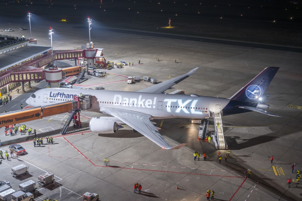 A Lufthansa aircraft at the finger of Terminal 1 in Tegel. Projected onto the aircraft: Danke TXL (in englisch: Thank you TXL)