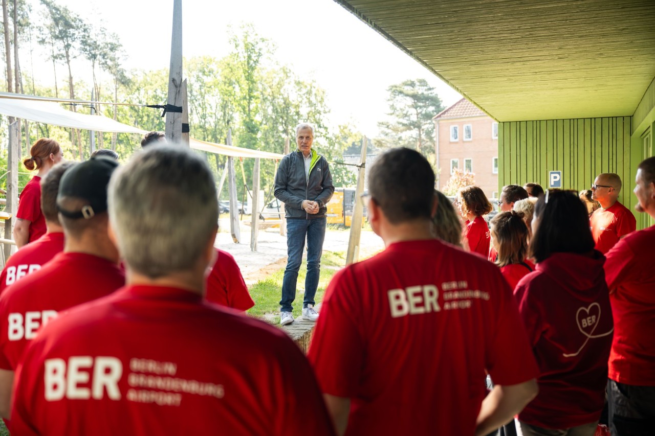 A man is giving a speech in front of a group of people.