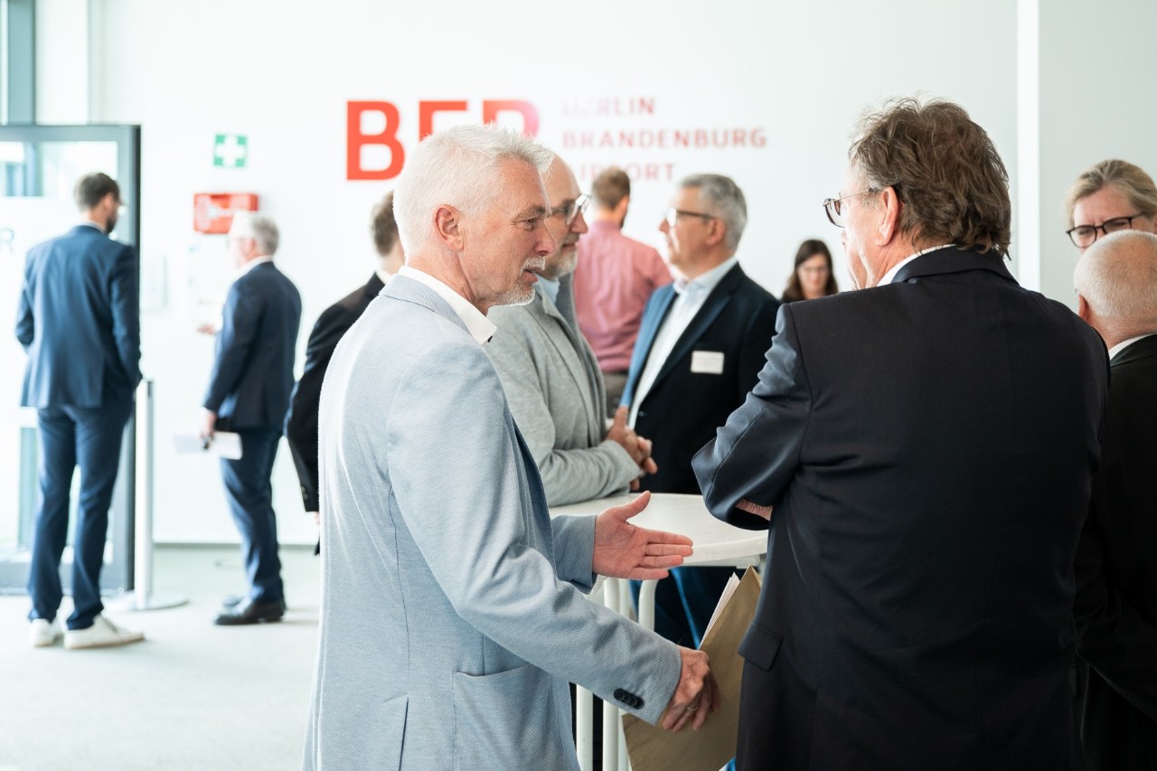 Several people are standing in a room and talking.