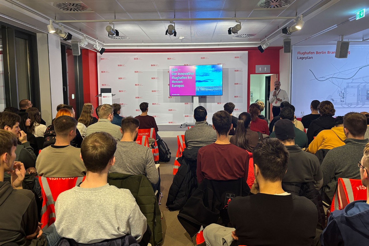 A group of students is sitting in a lecture hall