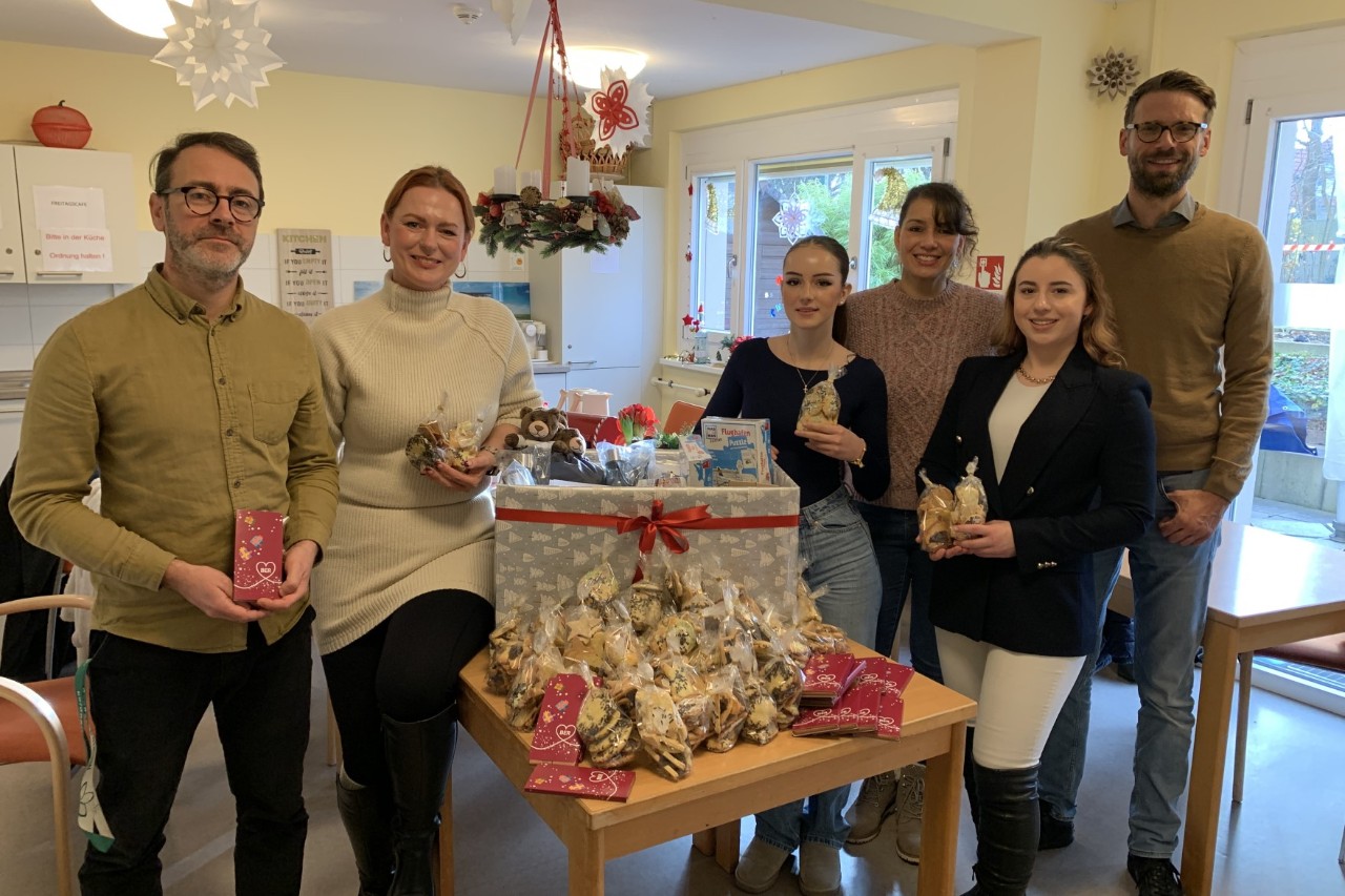 Six people pictured at the handing over of the gift basket.