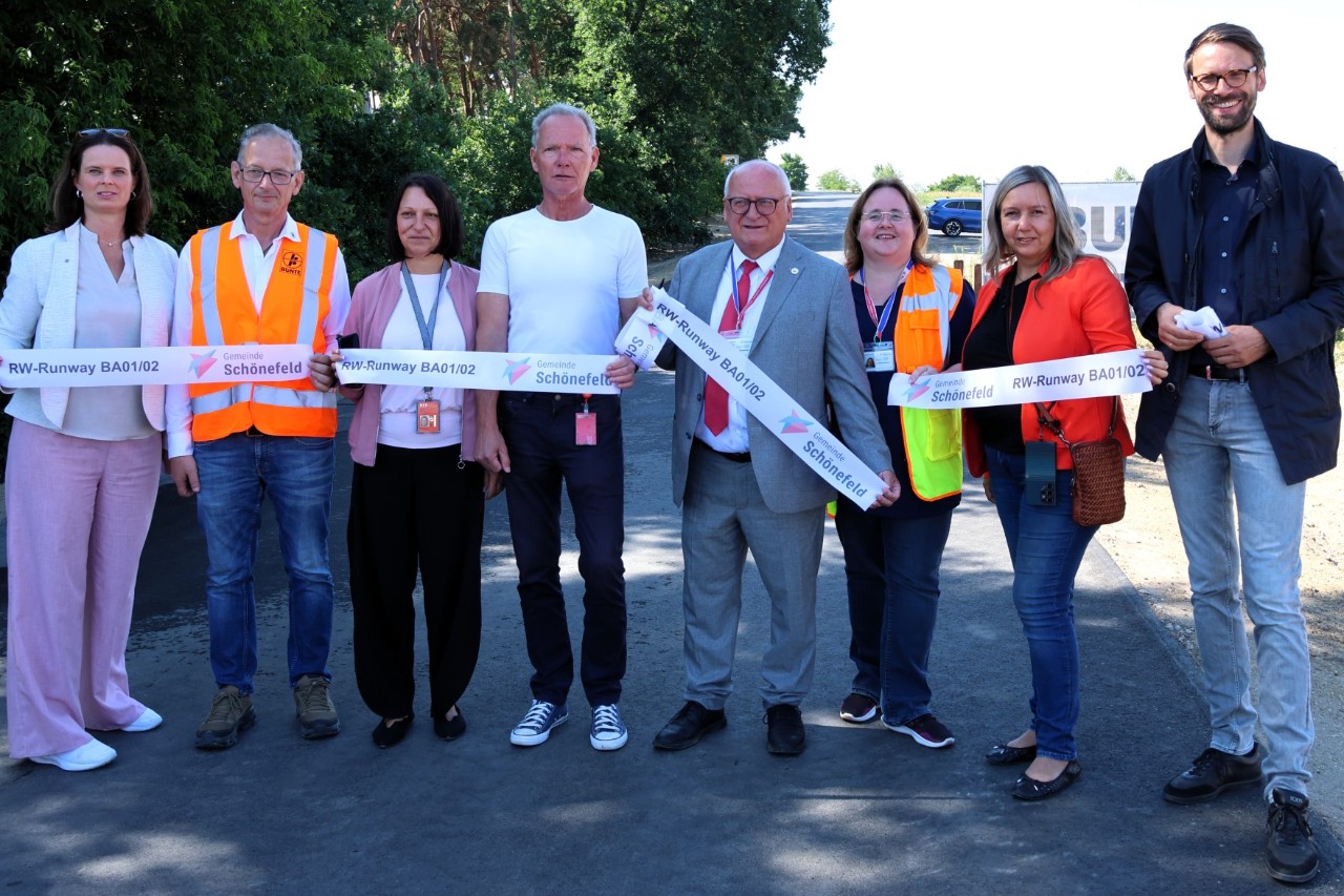 Eight people standing in a row on the newly opened cycle path.