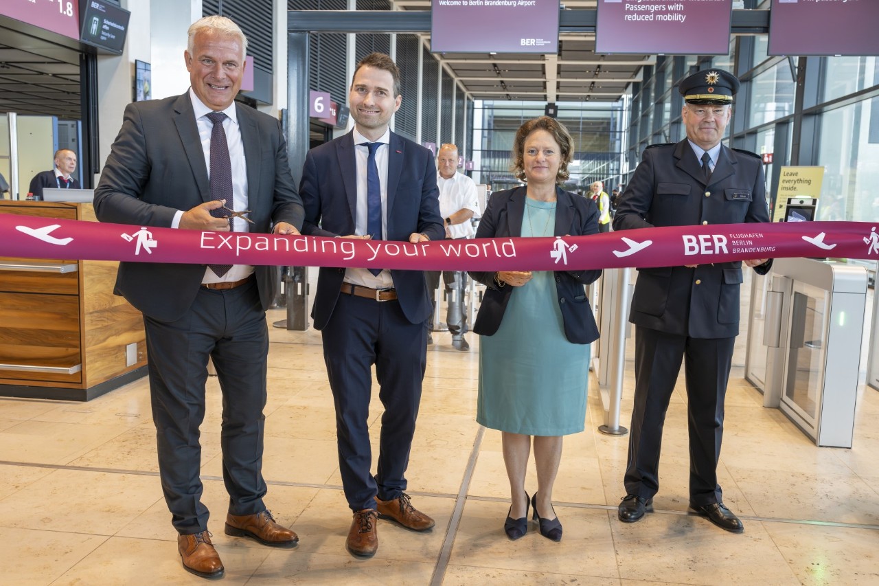 Four people cut a ribbon