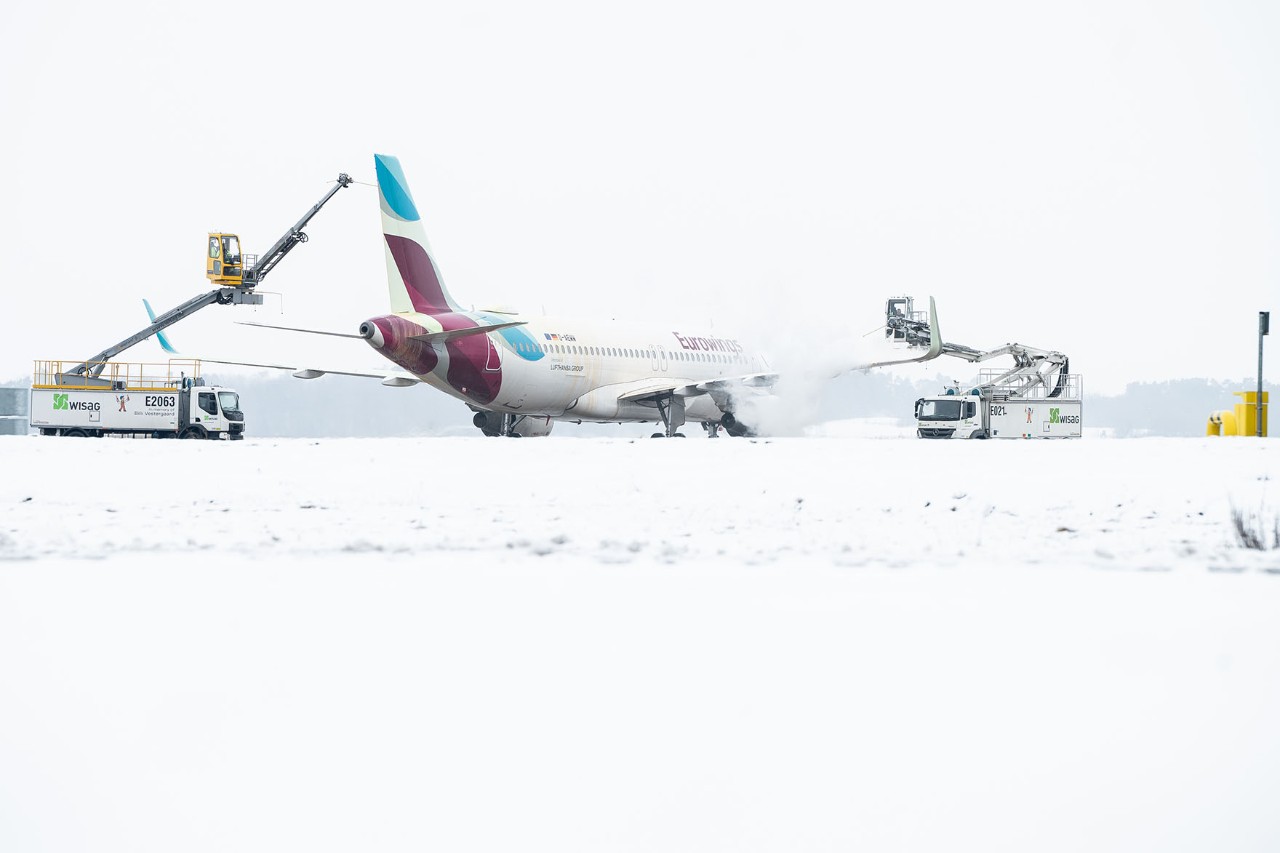 An aircraft is being de-iced on the apron.