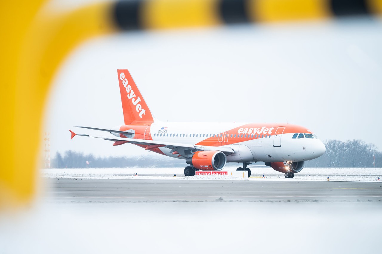 An easyJet aircraft stands on the winter runway.