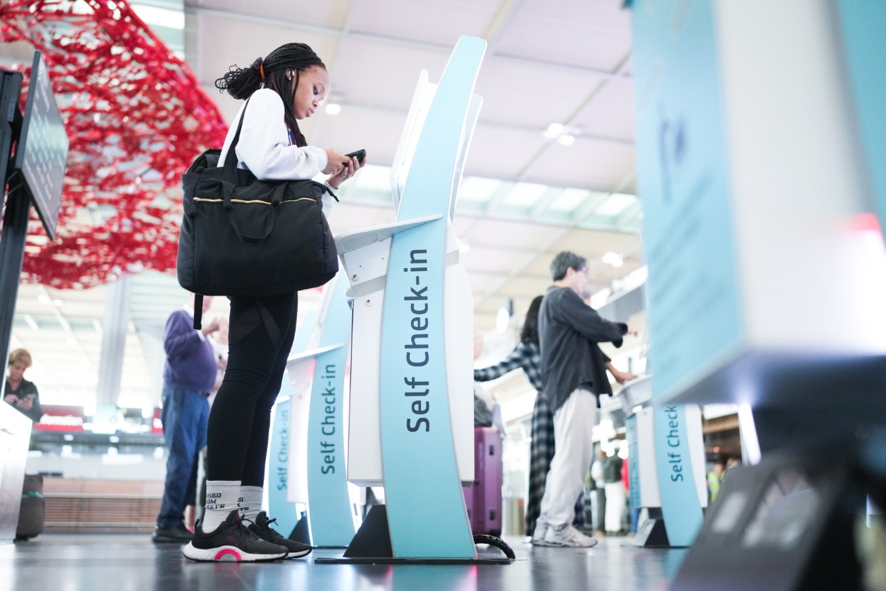 A woman at a self-check-in machine