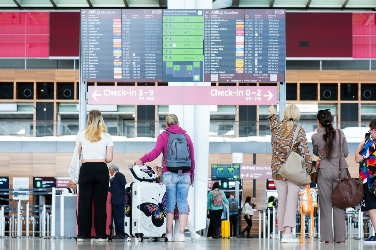 People in front of a display board at an airport