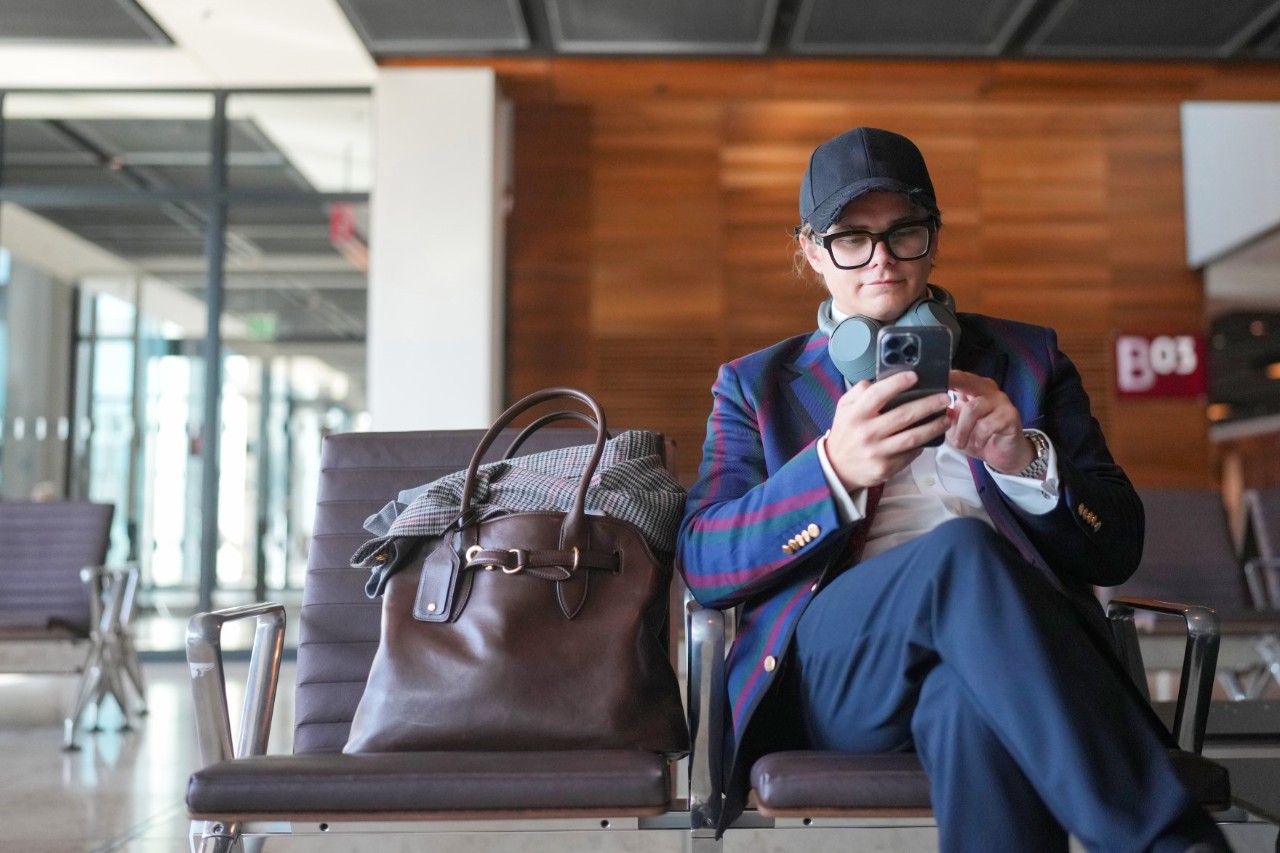 A person is sitting on a bench at an airport.