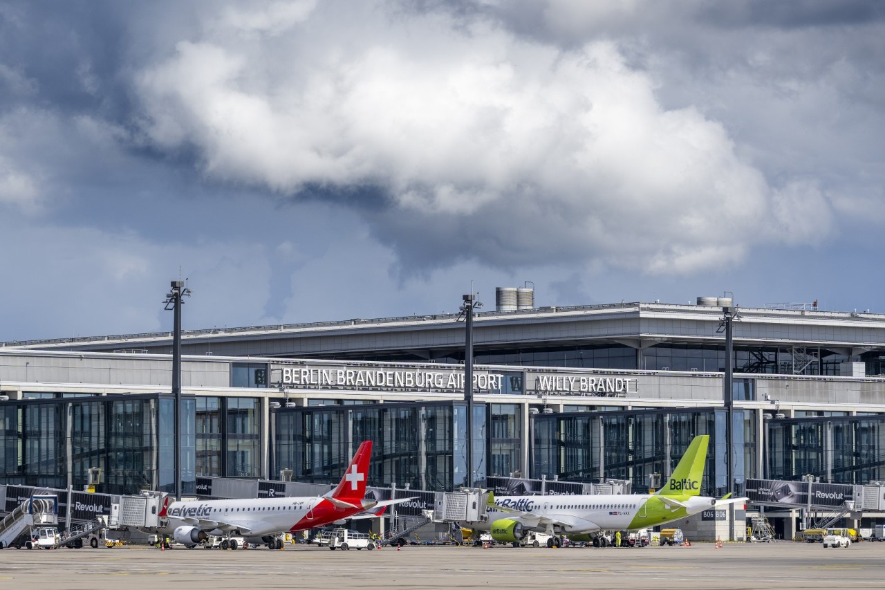 Several aeroplanes at an airport terminal.