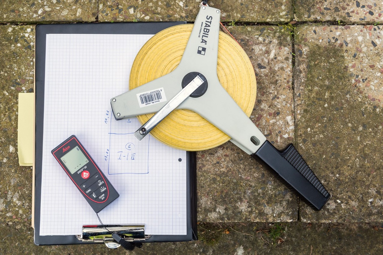 Measuring devices and a clipboard are lying on stepping stones.