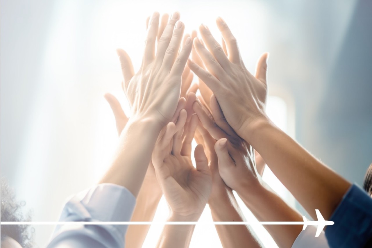 Six female-looking arms are raised in the air, about to give each other a group high-five. An aircraft pictogram has been added to the lower part of the image.
