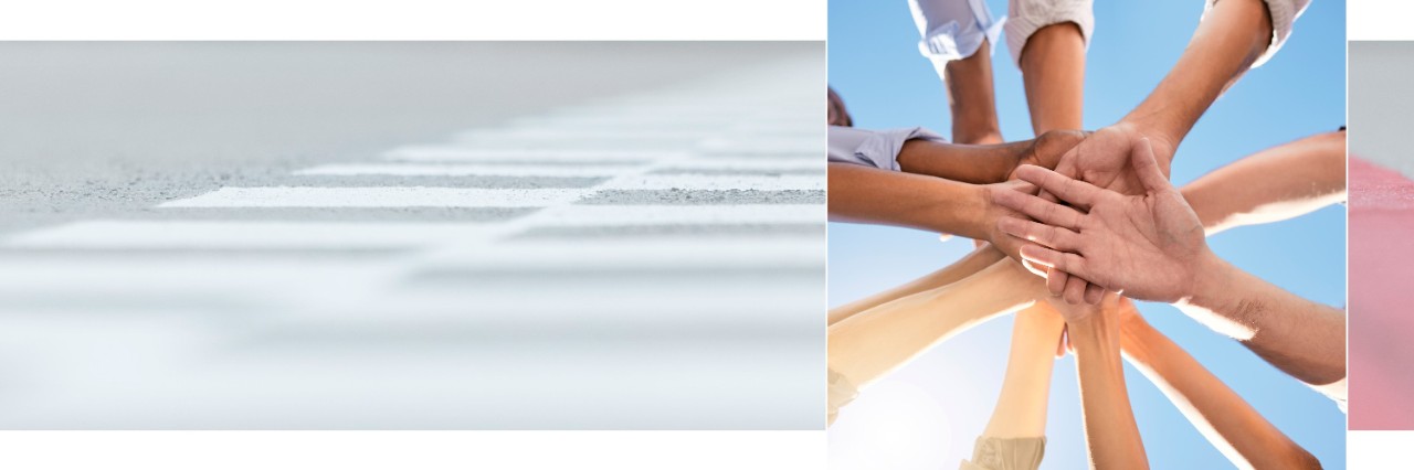 Shown are the stacked hands of a group of people standing in a circle.